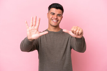 Young caucasian handsome man isolated on pink background counting six with fingers