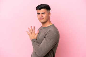 Young caucasian handsome man isolated on pink background scheming something