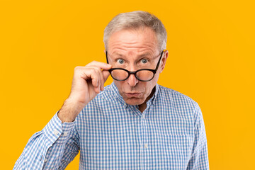 Surprised mature man in glasses staring at camera