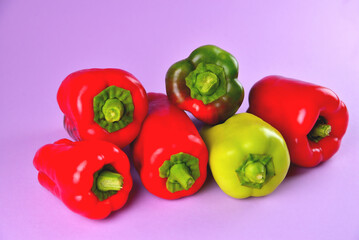 red and green sweet bell peppers on a purple background, fresh juicy vegetables on a colored background, soft focus, close-up
