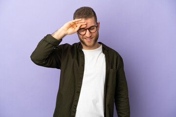 Young handsome caucasian man isolated on purple background with tired and sick expression