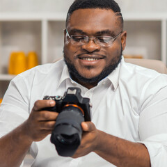 Young African-American photographer works in home office. Remote job concept.