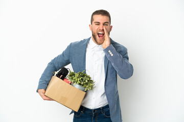 Young caucasian making a move while picking up a box full of things isolated on white background...