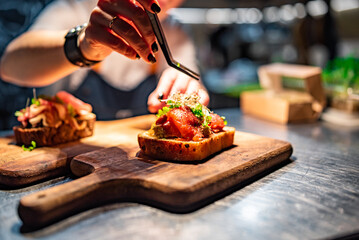Chef hand decorate toast with salted salmon and cream cheese on kitchen in restaurant