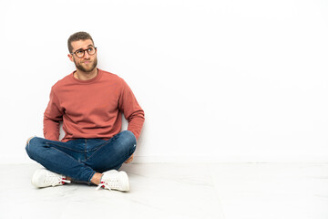 Young handsome man sitting on the floor and looking up