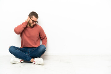 Young handsome man sitting on the floor with neckache