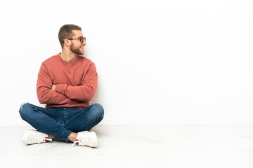 Young handsome man sitting on the floor in lateral position