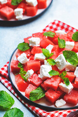 Refreshing summer juicy Watermelon salad with feta cheese and fresh mint, gray table background, top view, copy space
