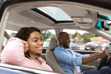 Happy black couple enjoying drive on new car