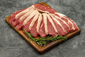 Beef fillet on a dark background. Raw beef tenderloin on wooden serving board. close up