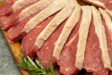 Beef fillet on a dark background. Raw beef tenderloin on wooden serving board. close up