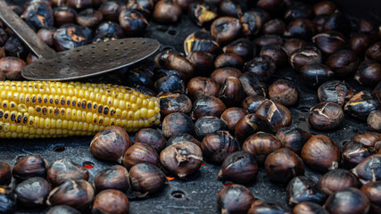 Chestnut and corn cob cooking on the barbecue with charcoal