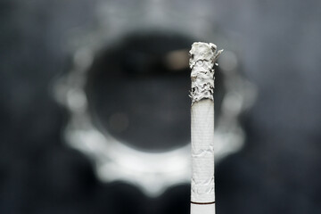 close up of burning cigarette on dark background 