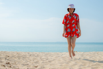 Portrait beautiful young asian woman relax walking leisure around sea beach ocean with white cloud on blue sky in travel vacation