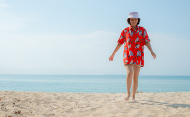 Portrait beautiful young asian woman relax walking leisure around sea beach ocean with white cloud on blue sky in travel vacation