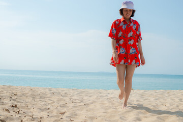 Portrait beautiful young asian woman relax walking leisure around sea beach ocean with white cloud on blue sky in travel vacation