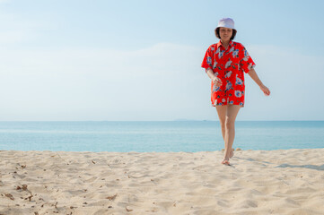 Portrait beautiful young asian woman relax walking leisure around sea beach ocean with white cloud on blue sky in travel vacation