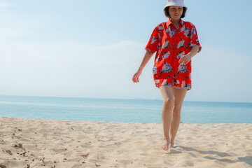 Portrait beautiful young asian woman relax walking leisure around sea beach ocean with white cloud on blue sky in travel vacation