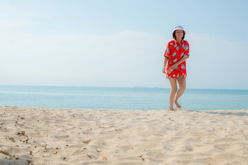 Fototapeta na wymiar Portrait beautiful young asian woman relax walking leisure around sea beach ocean with white cloud on blue sky in travel vacation