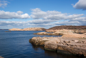 Fototapeta na wymiar Seascape with red granite boulders and blue summer sky at the swedish west coast.