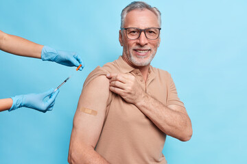 Vaccine injection against coronavirus. Pleased old man being immunized against covid 19 at hospital...