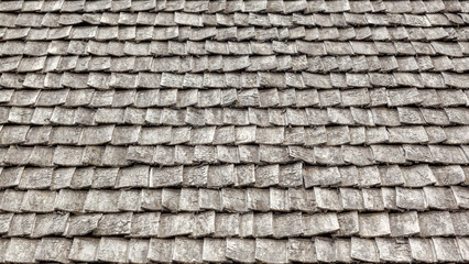 Weathered wooden shingles on a roof. wooden roof tile of old house