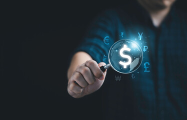 Businessman holding magnifier glass with virtual world with currency sign include dollar euro pound Yuan and Yen for money exchange and transfer concept.