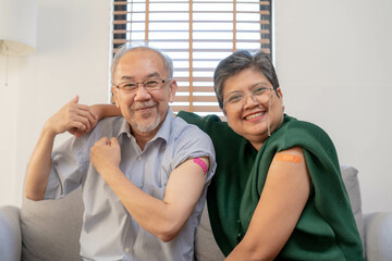 Coronavirus Vaccination, happy asian elderly, aged family smile strong together, showing bandage on...