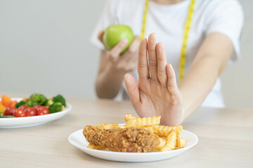 Diet, Dieting asian young woman hand in push out, deny fried chicken, french fried and choose green apple, vegetables salad, eat food for good healthy, health when hungry. Female weight loss people.