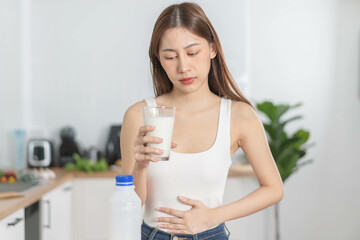 Pain, Allergy asian young woman, girl hand in belly suffer after drink glass of milk, unhappy and bad stomach ache. Lactose intolerance and dairy food , health problem concept.