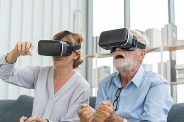 Naklejka na ściany i meble Happy senior couple, elderly family, caucasians mature, adult lover and retired man, woman wearing VR headset or visual reality goggles, gadget, play video game of simulator futuristic of technology