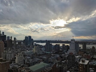 Naklejka na ściany i meble Sunset and clouds over New Jersey from Midtown Manhattan, New York City - April 2022