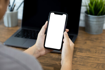 Hands of a woman using a  smartphone mockup at his desk. Mobile phone blank screen for editing graphics.