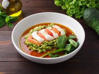 Healthy snack with avocado, squid, grapefruit and basil. Close up. Mashed avocado puree, sauce, seafood. Copy space. The concept of healthy eating. Healthy food. Top view. Wooden background. Diet food