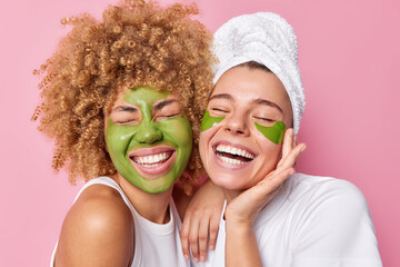 Positive women feel joyful smile broadly keep eyes closed apply green nourishing mask and patches...