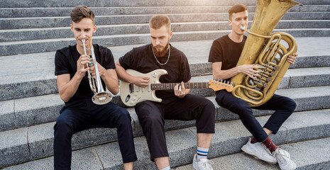Young street music band play a lot of musical instruments