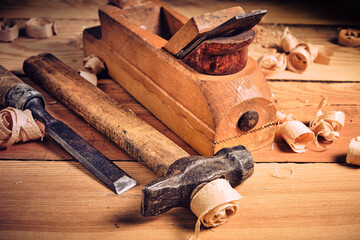 Set of tools for carpenters, hammer, chisel and plane on wooden background.