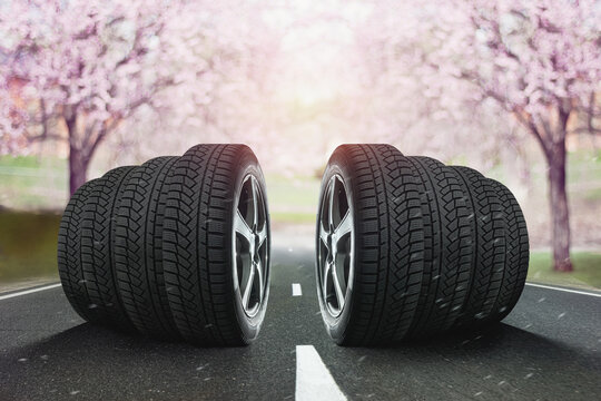  Car tires standing on the road against sun light of headlights in spring.