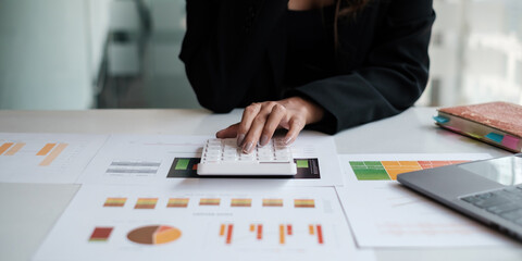 Close up Business woman hand using calculator to calculate the company's financial results and budget. Account Audit Concept.