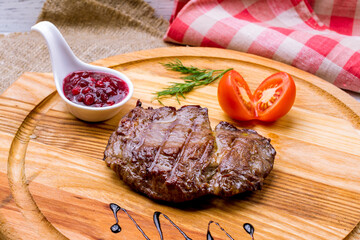 roast beef Steak with berry sauce on the board macro close up