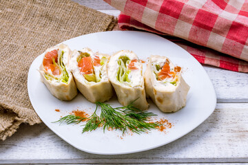 roll with salmon and philadelphia cheese on white plate