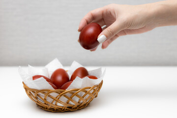 woman takes out an easter egg from a wicker basket