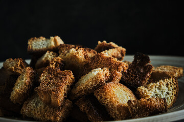 Wooden plate with fried breadcrumbs dark background. Rustic setting and food.