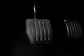 Pedals on the floor of a car.