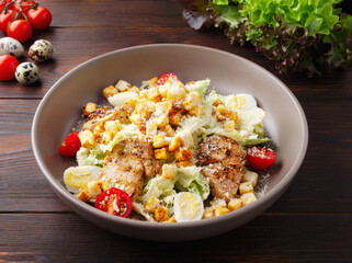 Shrimp tail salad grilled chicken, arugula, quail eggs, cherry tomatoes, crackers, olive oil and balsamic vinegar. Top view. Copy space. Close up. Wood background. Lunch, dinner in a cafe, restaurant.
