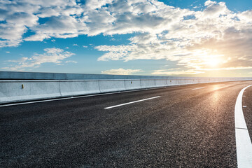 Empty asphalt road and sky clouds at sunrise