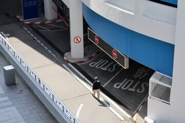 Man walking across parking entrance