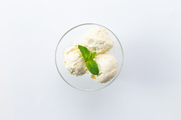 Three scoops of ice cream in a glass bowl. View from above. On a white background.