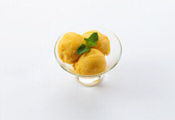 Three scoops of vanilla ice cream in a glass bowl. On a white background. Selective focus.