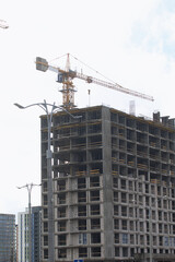 Construction of multi-storey buildings. Modern multi-storey building. Completed and under construction buildings. Construction cranes are visible.